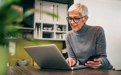 55+ student woking on course work at her kitchen table