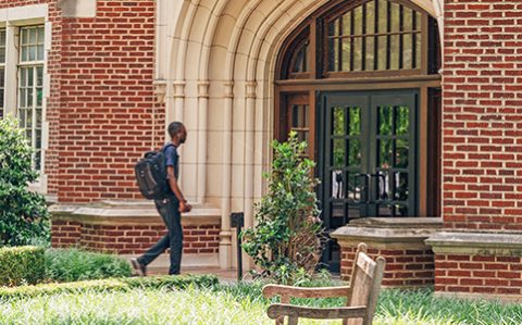 Decorative photo of OU student with a backpack on walking into a university building