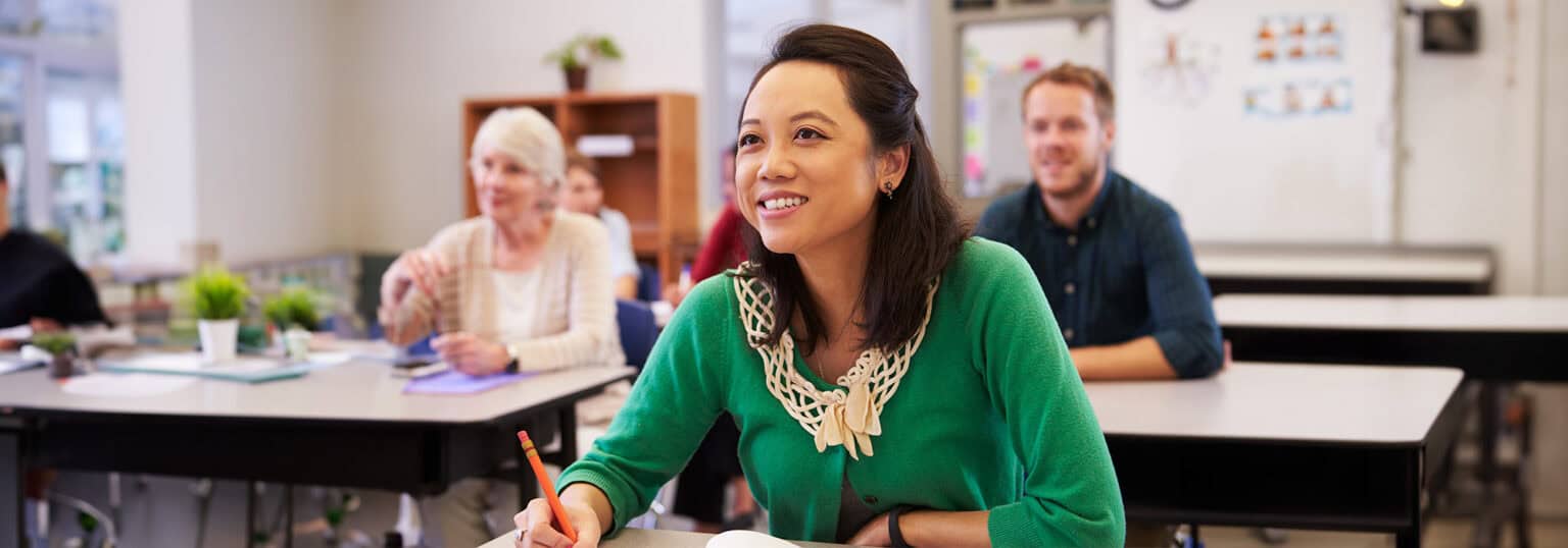 Young woman in a classroom with other students.