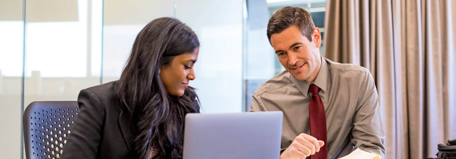 Man and woman in office looking at computer