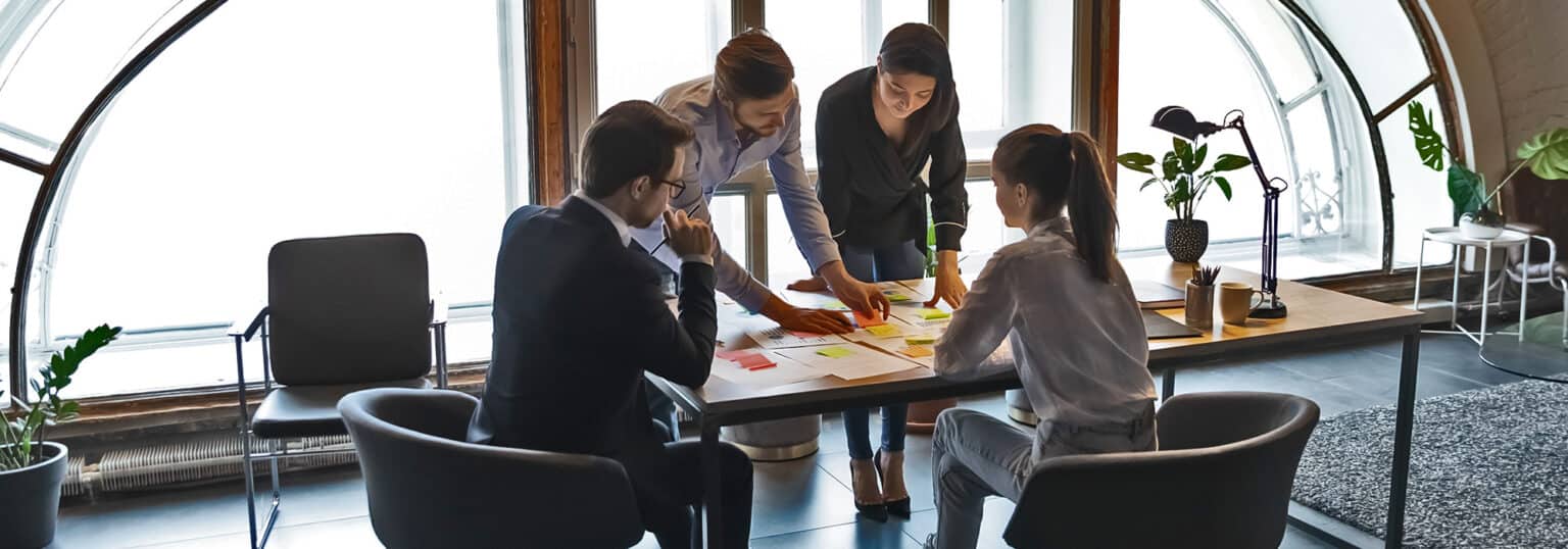 A group of people analyzing information in an office setting.