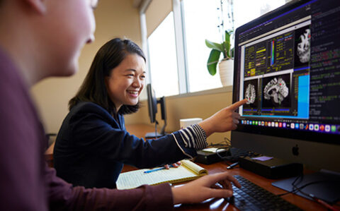 two people looking at medical scans on a screen