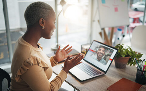 professor meeting remotely with her student using Zoom on her laptop