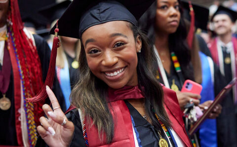 smiling OU graduate celebrating during college graduation ceremony