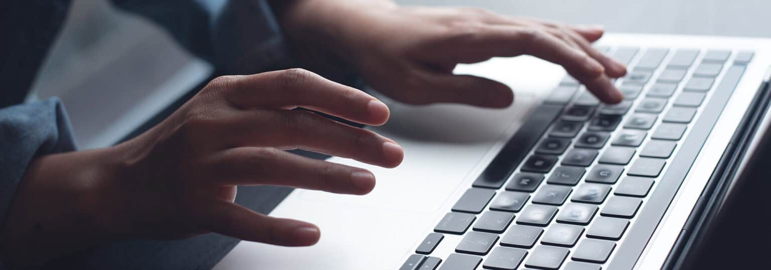 Hands typing on a keyboard.