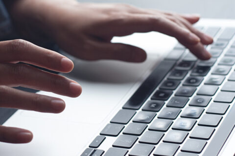 Hands typing on a keyboard.