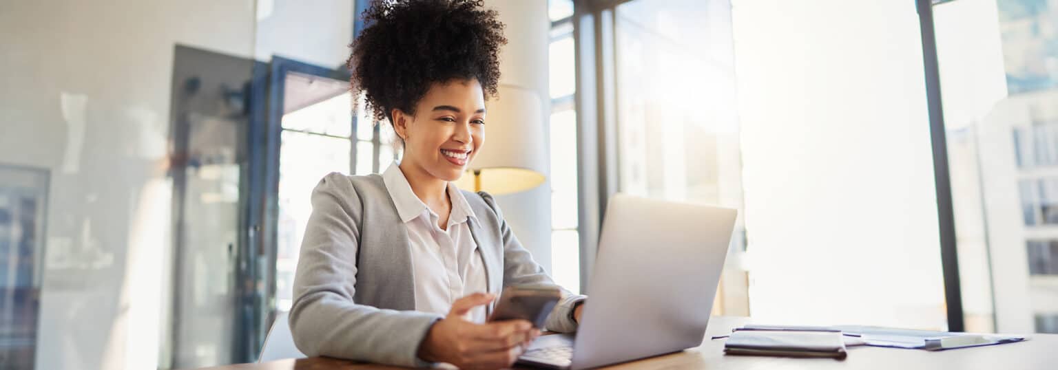 Smiling woman looking at a laptop.