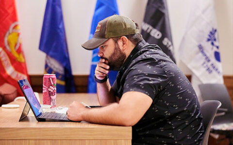 military connected student at a desk with his laptop