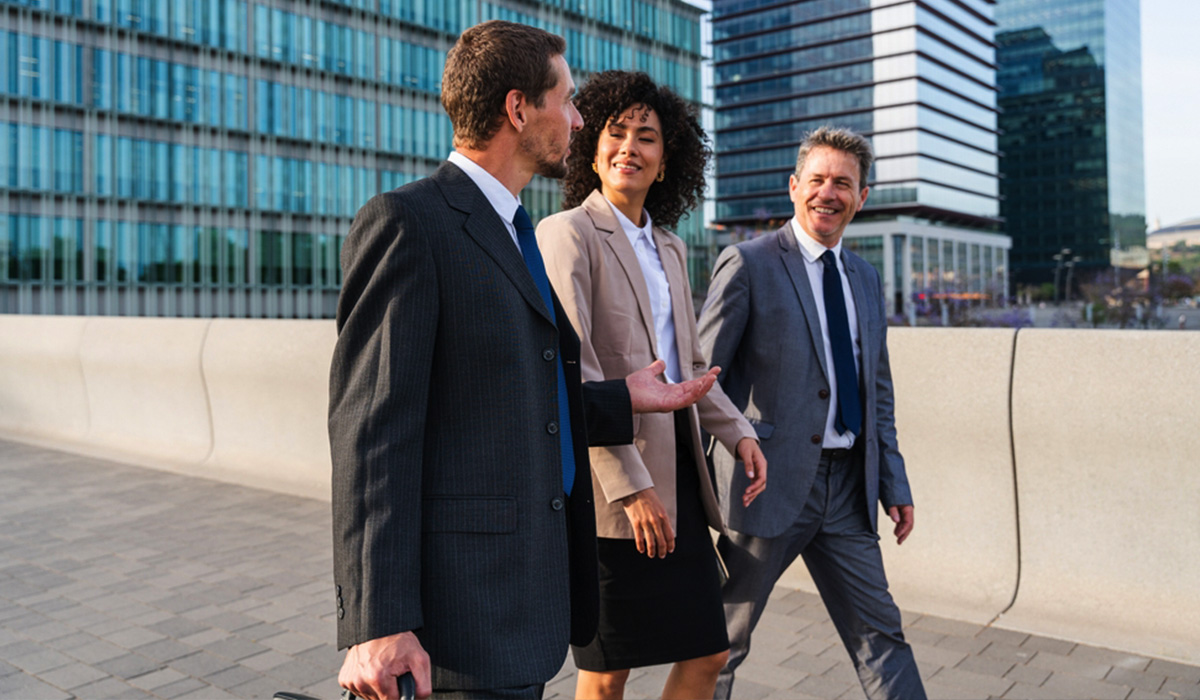 three criminal justice professionals walking and talking on sidewalk outside a courthouse