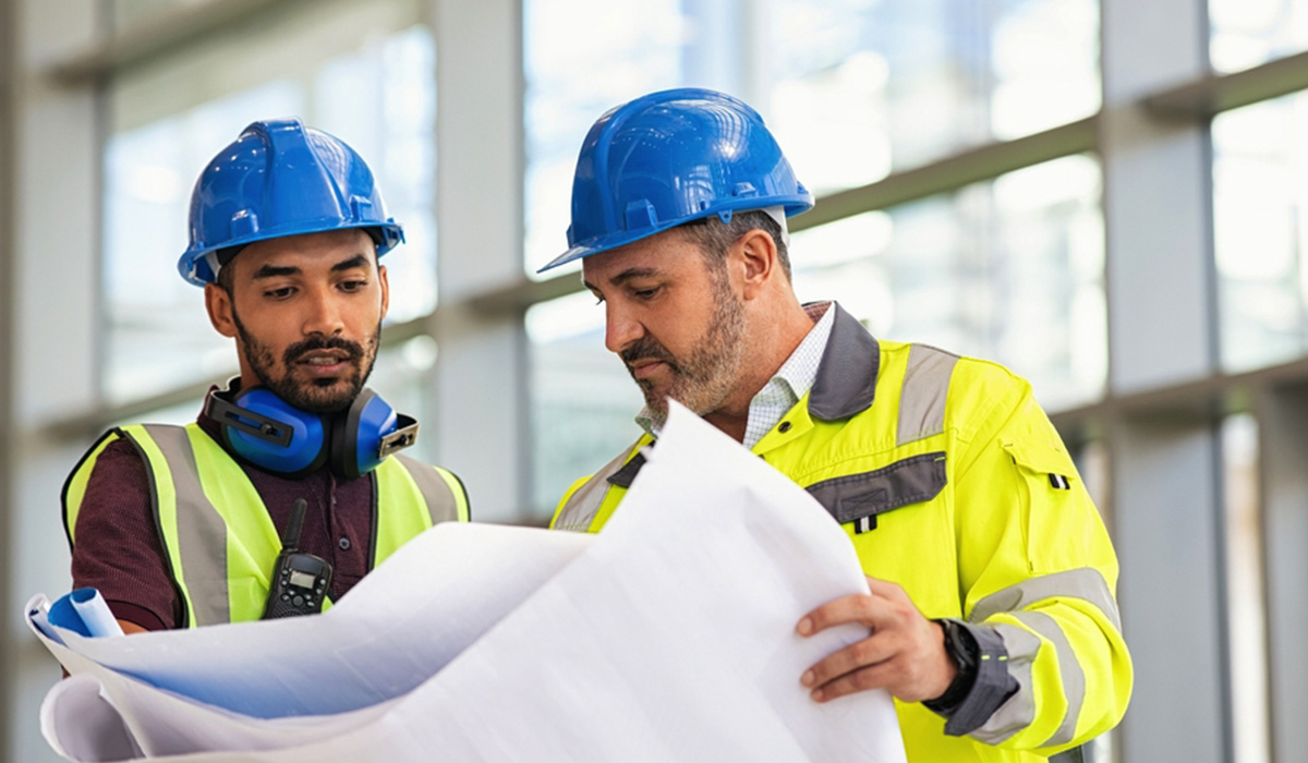 two construction management professional looking at site plans