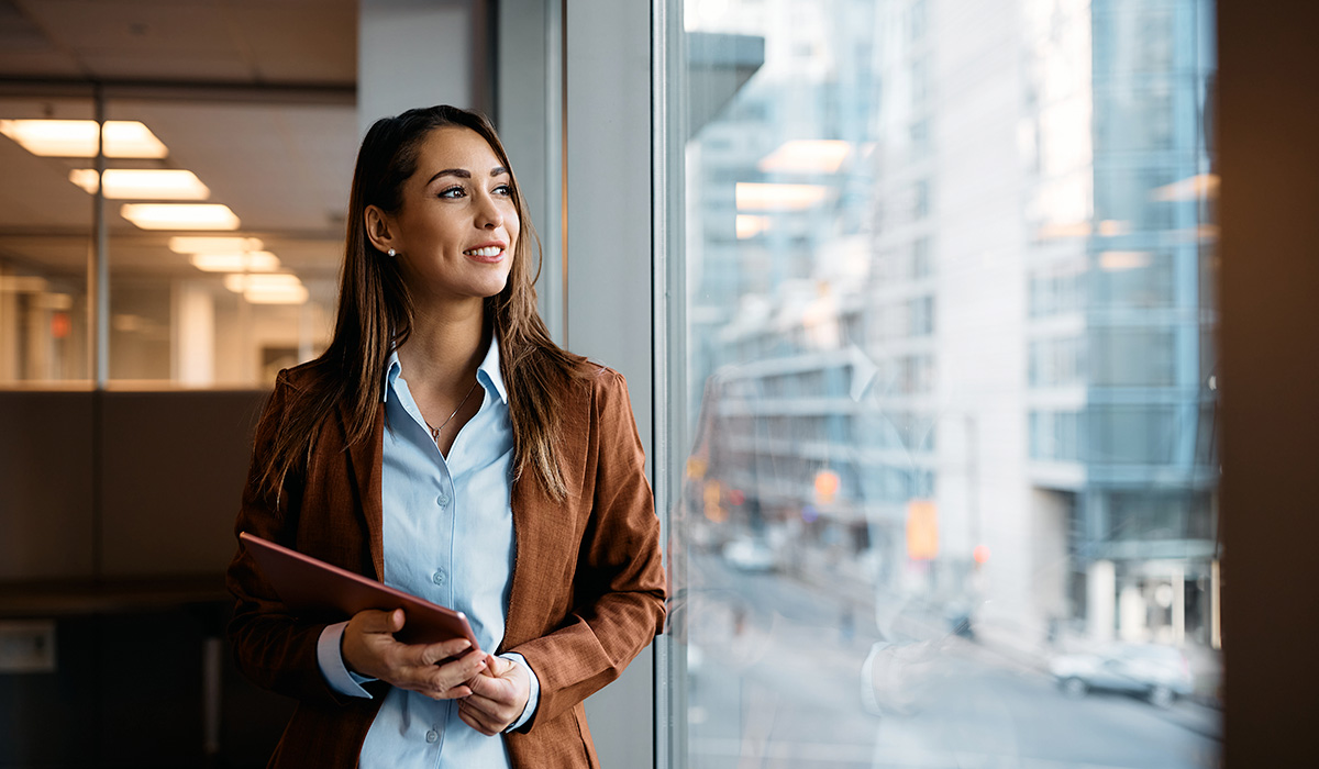 young entrepreneur standing near an office window and smiling