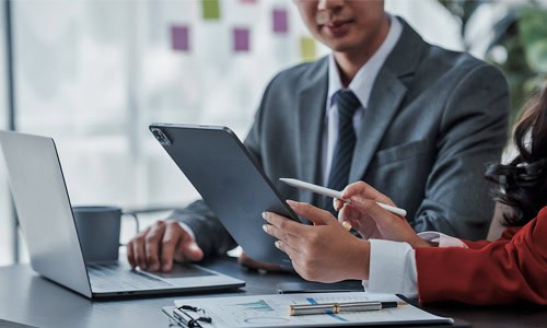 decorative image of data analysts viewing data on laptop and tablet