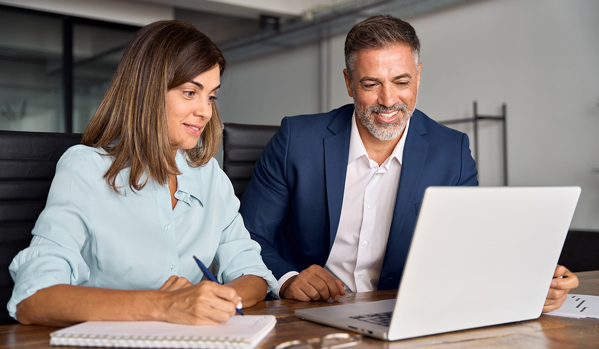 energy executives reviewing data on laptop