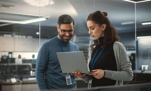 decorative image of engineering professions reviewing a project on a laptop