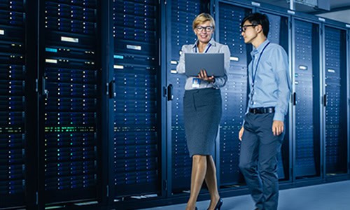 decorative image of 2 computer techs walking past servers