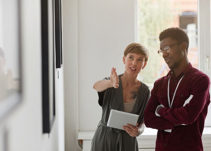 two art gallery professionals discussing the set up for an exhibition