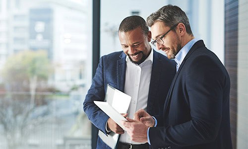 decorative image of 2 finance professionals viewing data charts