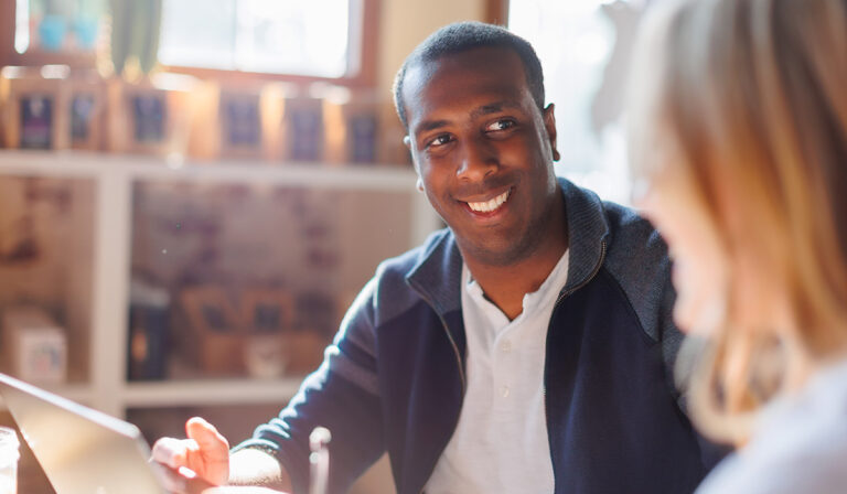 Smiling student sitting in front of a window