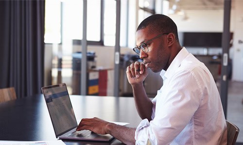 decorative image of healthcare legal professional in viewing reports on his laptop