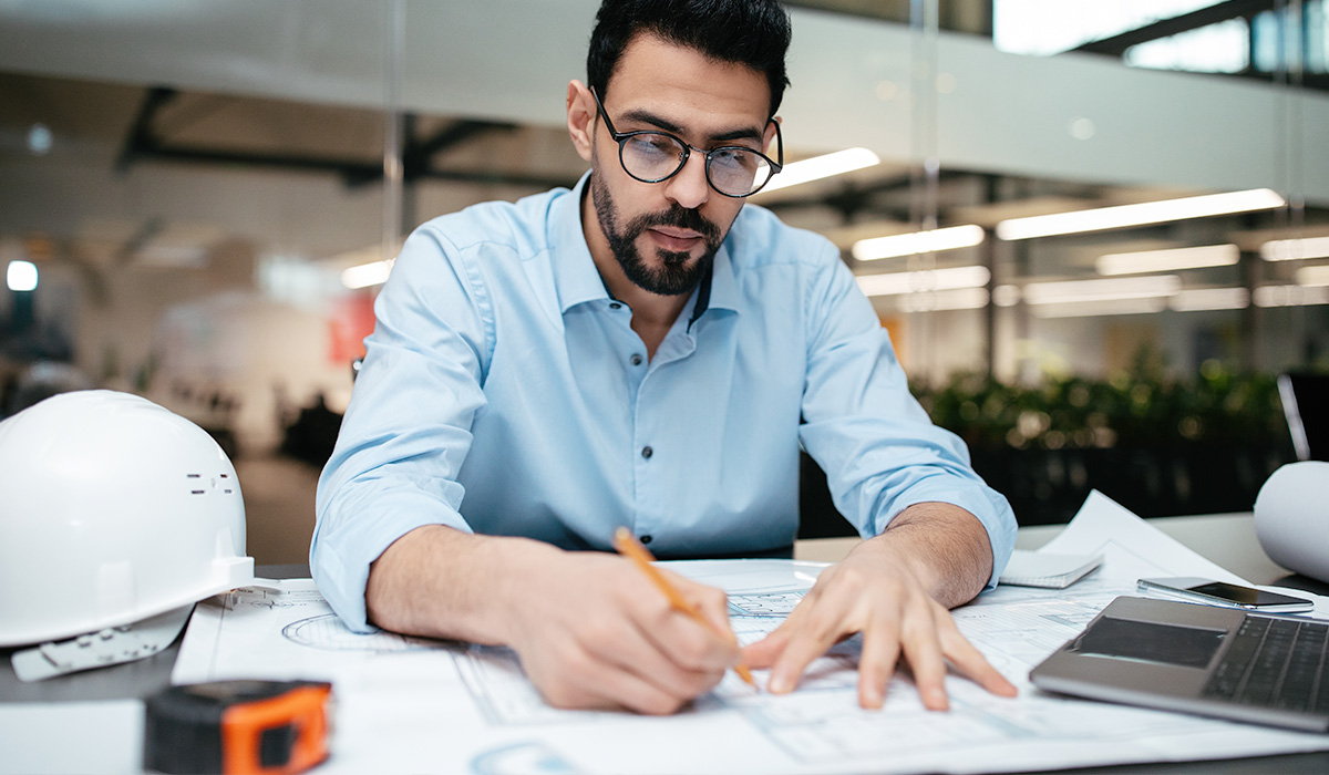 engineer working on project plans at his desk