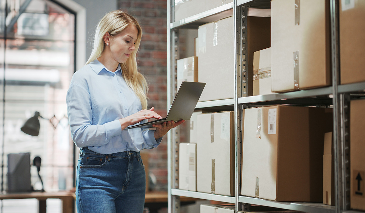 manager with a laptop inspecting parcels