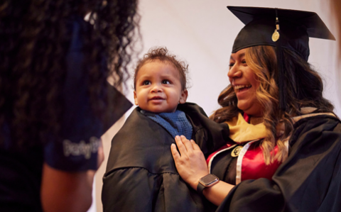 graduating student holding her baby