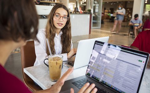 students working on laptops in a cafe