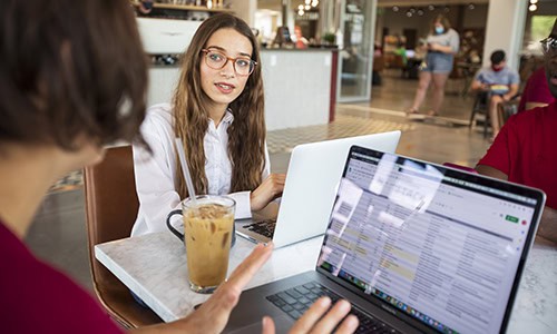 students working on laptops in a cafe