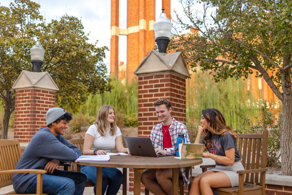 decorative images of students around a table outside near Bizzell Library