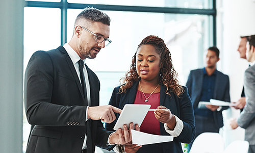International Law Professionals standing in an office and using a table to discuss a case
