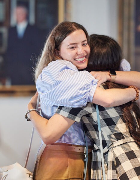 Two College of Public Heath alumni hugging at a reception