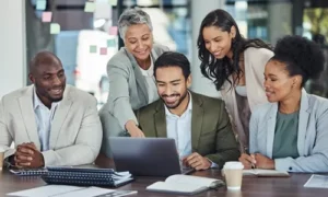 Five business leaders viewing reports on a laptop