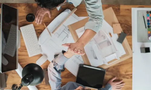 sustainable designers giving a high 5 over architectural drawings