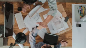 sustainable designers giving a high 5 over architectural drawings